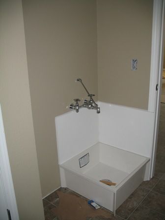 a corner bathtub in the middle of a room with tile flooring and walls