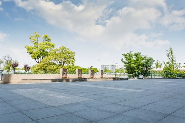 an empty parking lot with trees in the background