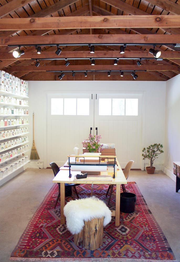 a living room filled with lots of furniture and decor on top of a red rug