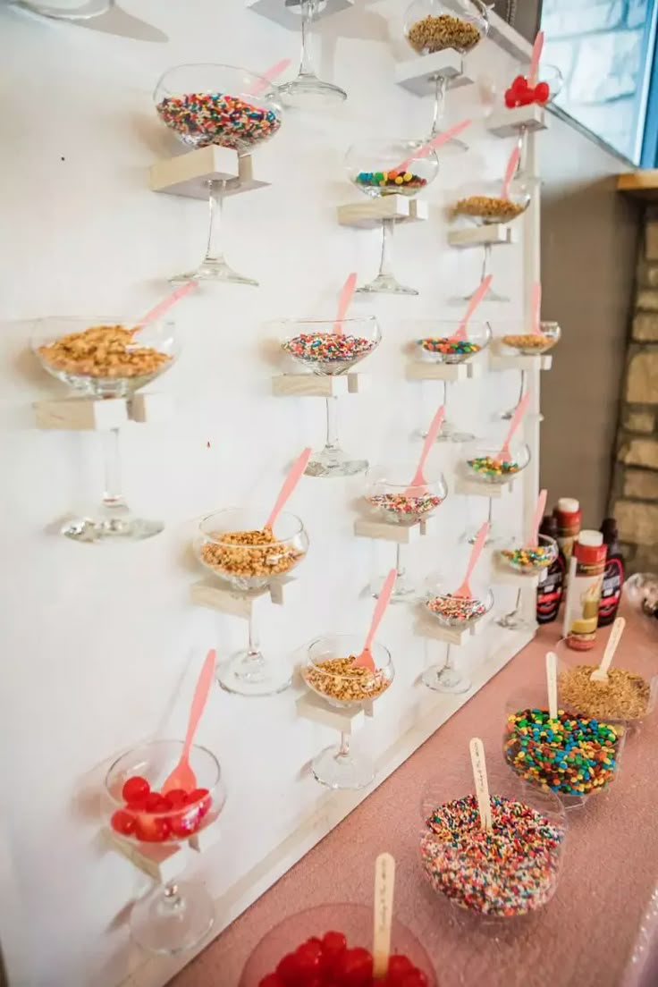 desserts are lined up on the wall with candy and candies in glass bowls