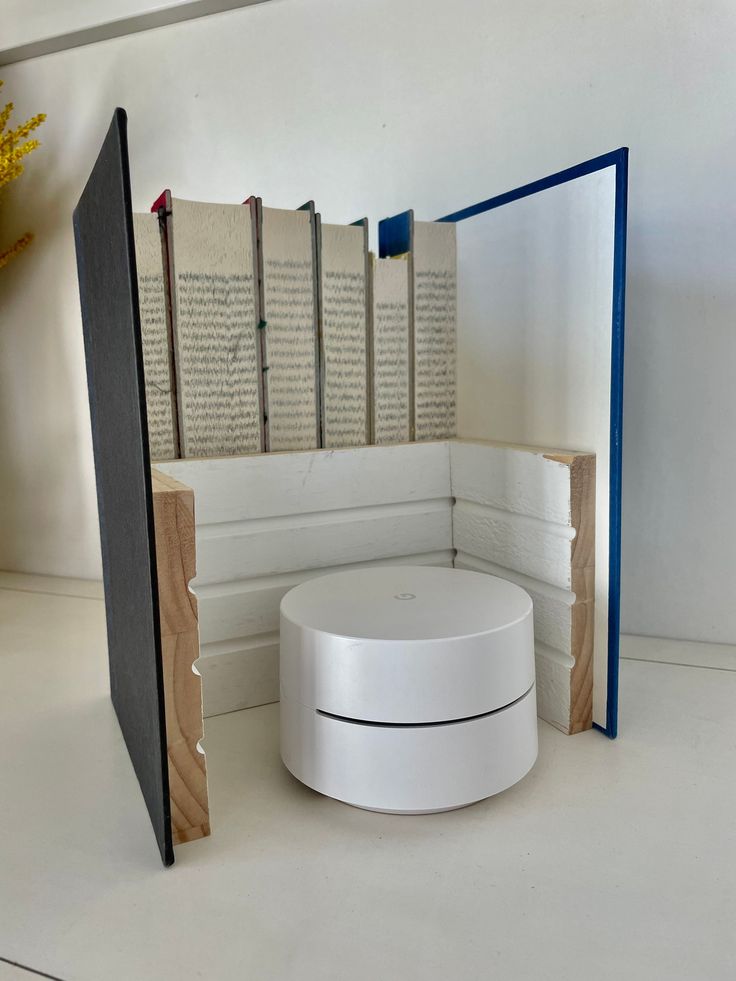 an open book sitting on top of a table next to a white object with blue trim