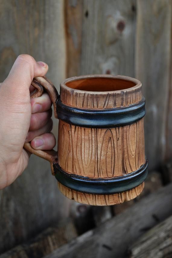 a person holding a wooden mug in their hand