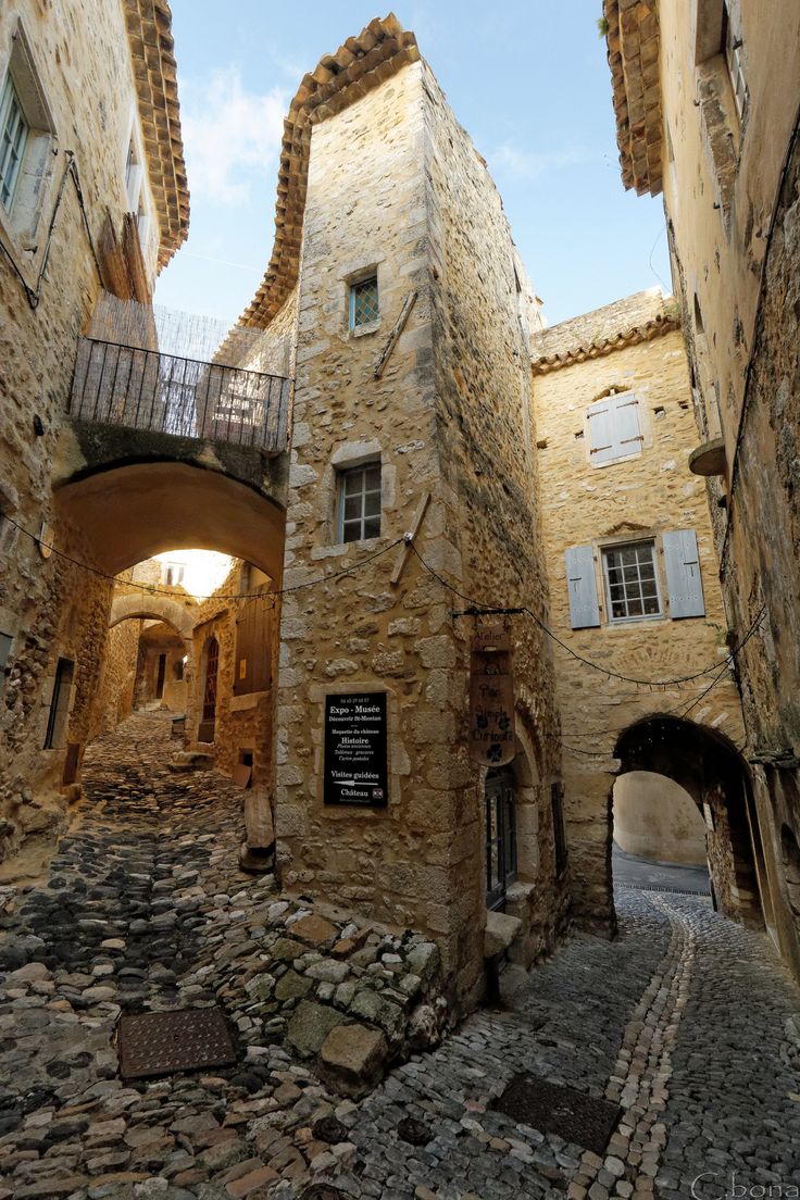 an alley way with stone buildings and cobblestones