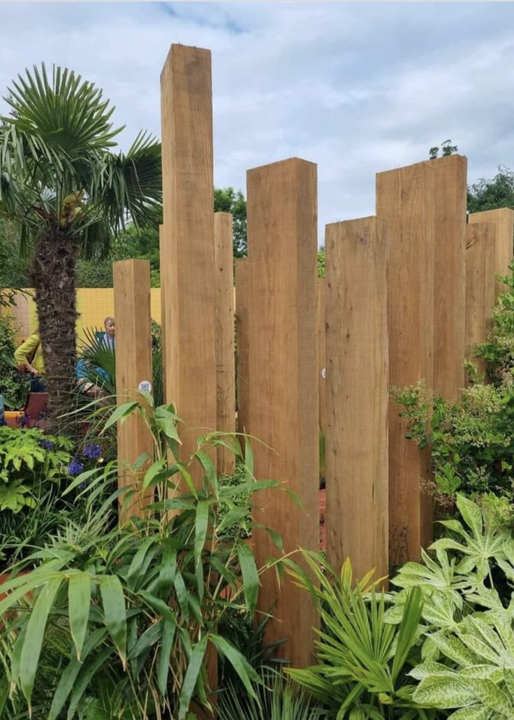 a wooden fence surrounded by plants and trees