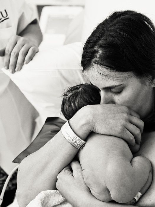 a woman holding a baby in her arms while it is being held by someone else