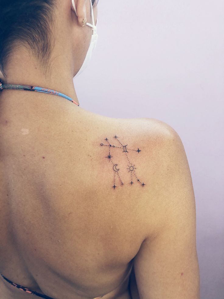 the back of a woman's shoulder with stars on her left side and an arrow in the middle