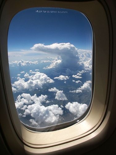 an airplane window looking out at the clouds