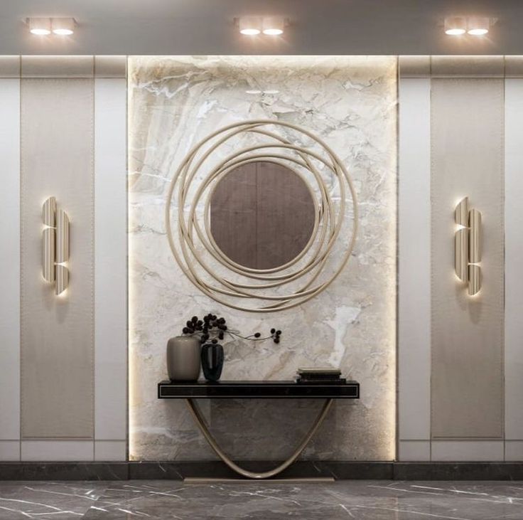 an elegant bathroom with marble walls and flooring, mirrors on the wall, two vases in front of it