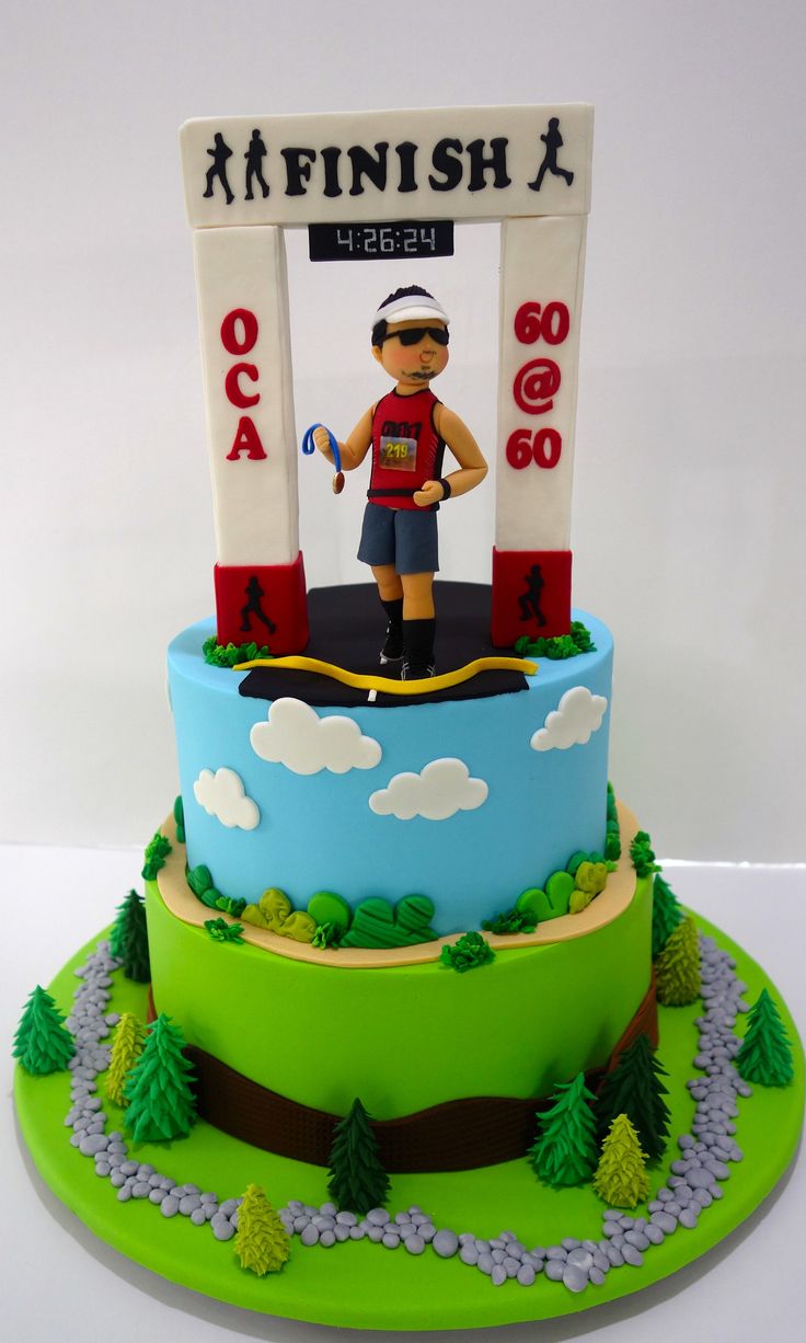 a cake with a man standing on top of it in front of a finish sign