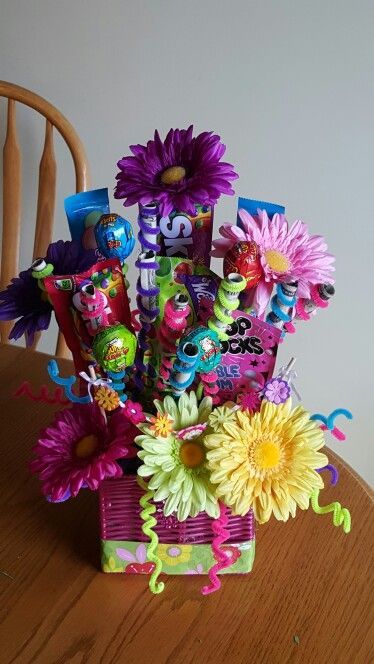 a basket filled with candy and flowers on top of a table