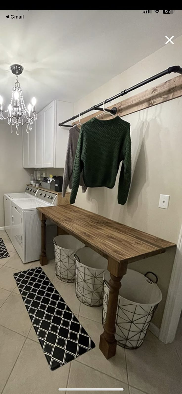 an image of a laundry room setting with clothes hanging on the rack and baskets underneath