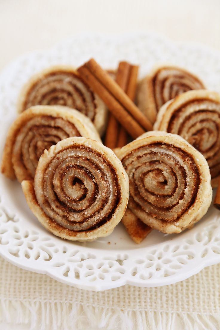 cinnamon rolls on a plate with cinnamon sticks