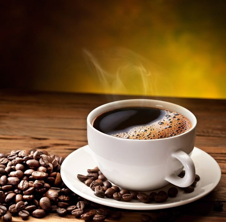 a cup of coffee and beans on a wooden table