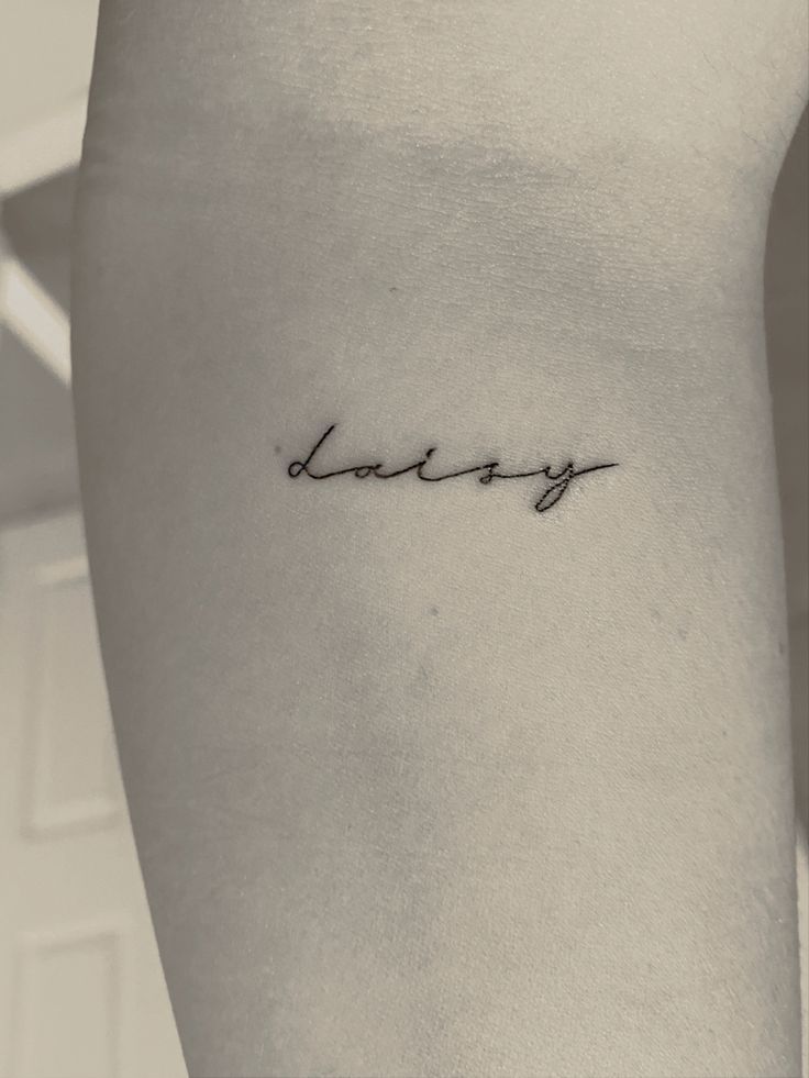 a woman's lower arm with the word lovey written in cursive font