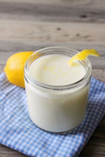 a glass jar filled with yogurt sitting on top of a blue and white towel