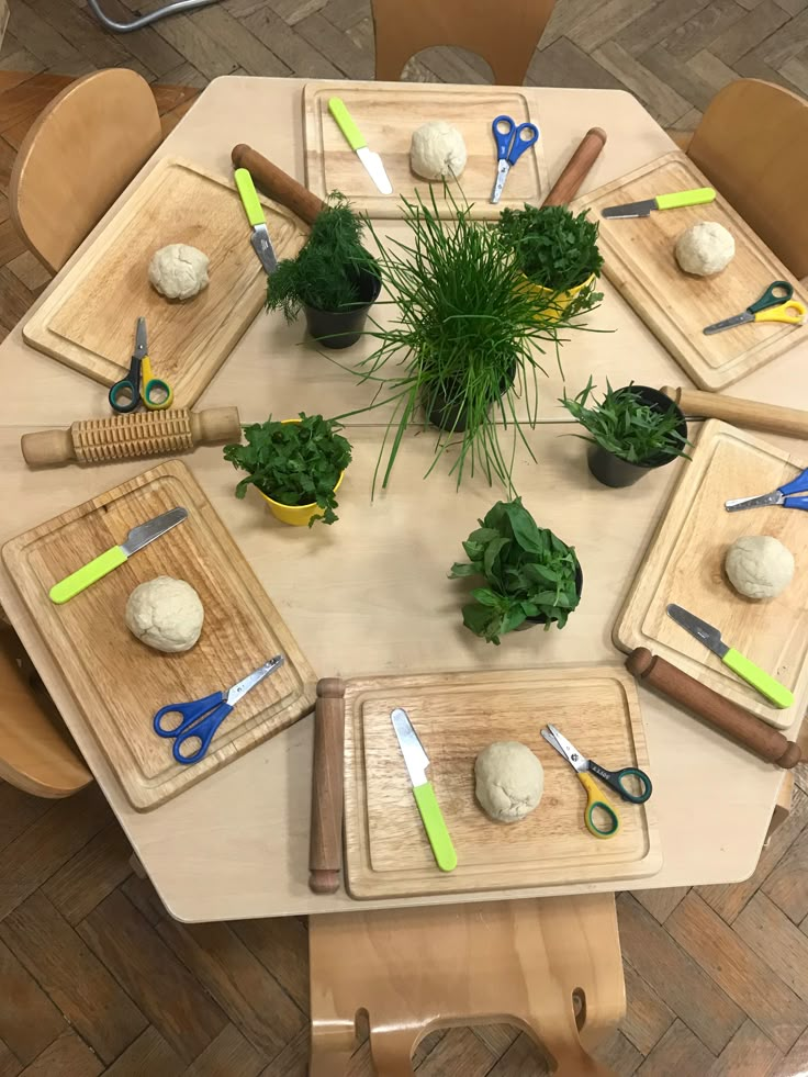 a table topped with cutting boards and potted plants