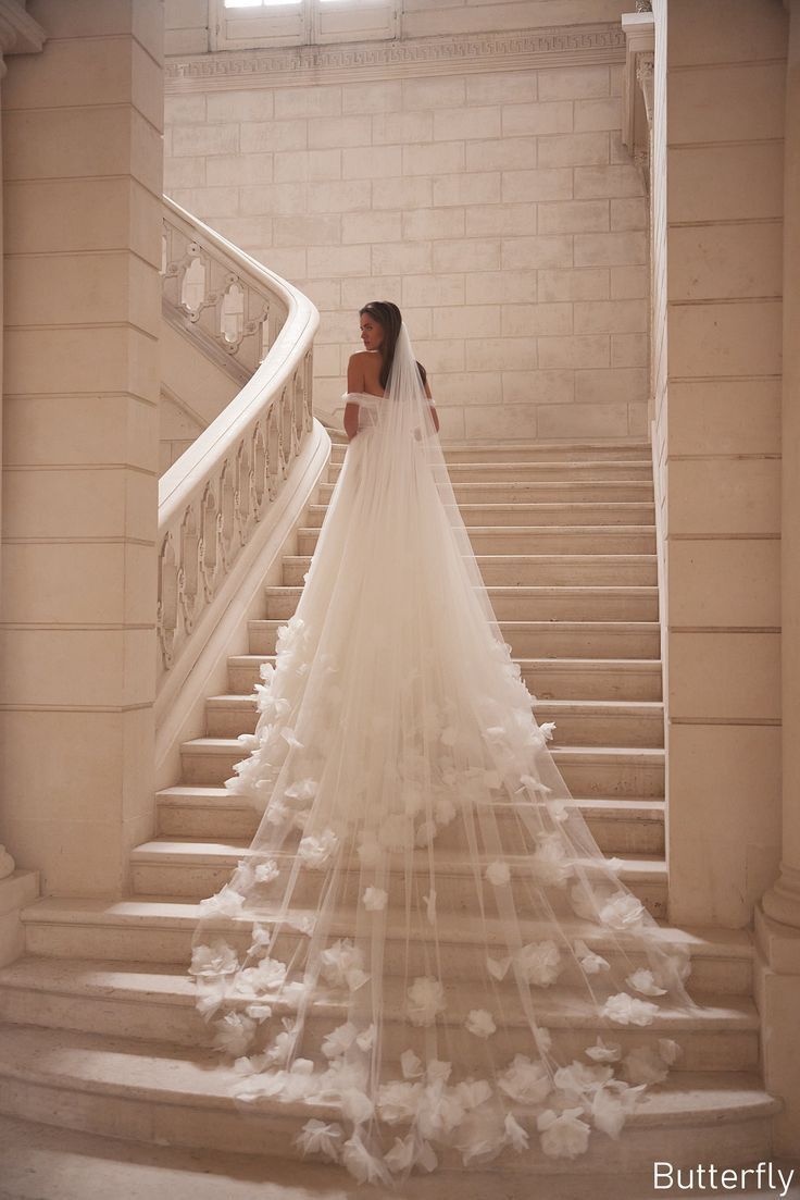 a woman in a wedding dress is walking down the stairs