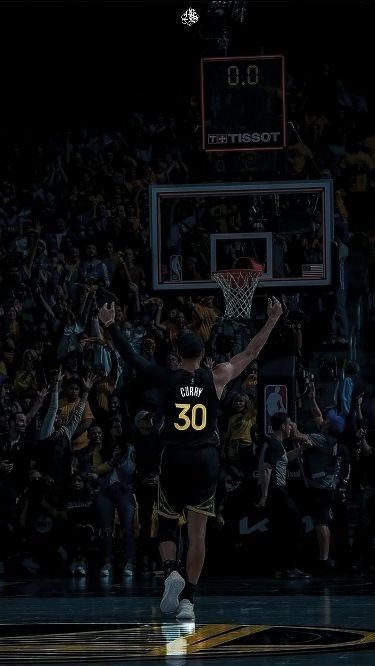 a basketball player is jumping up to dunk the ball in front of an audience