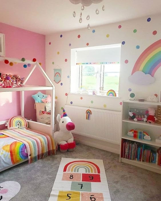 a child's bedroom decorated in pink, white and multicolored polka dots