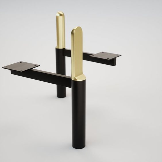 two black and gold metal objects on a white surface, one is standing up with its arms extended