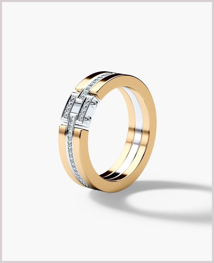 two tone gold wedding ring with diamonds on the sides and an open band, set against a white background