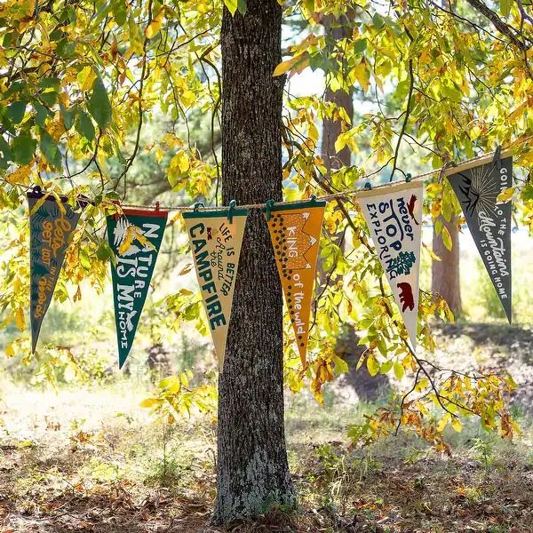 several banners are hanging from a tree in the woods