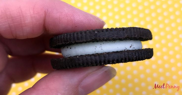 a person is holding an oreo sandwich in their hand