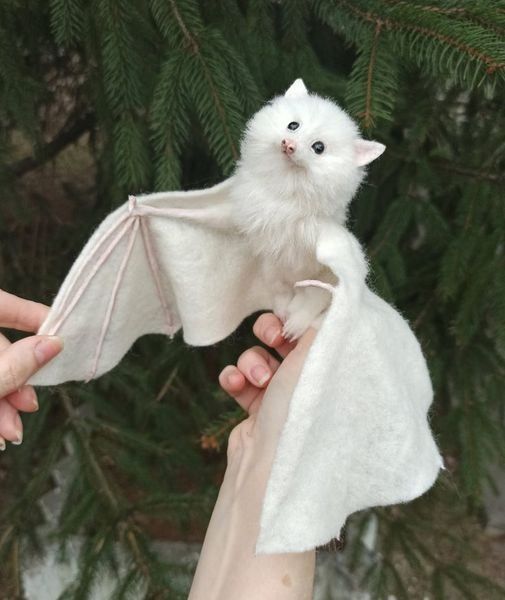 a person holding a stuffed animal bat in their hand