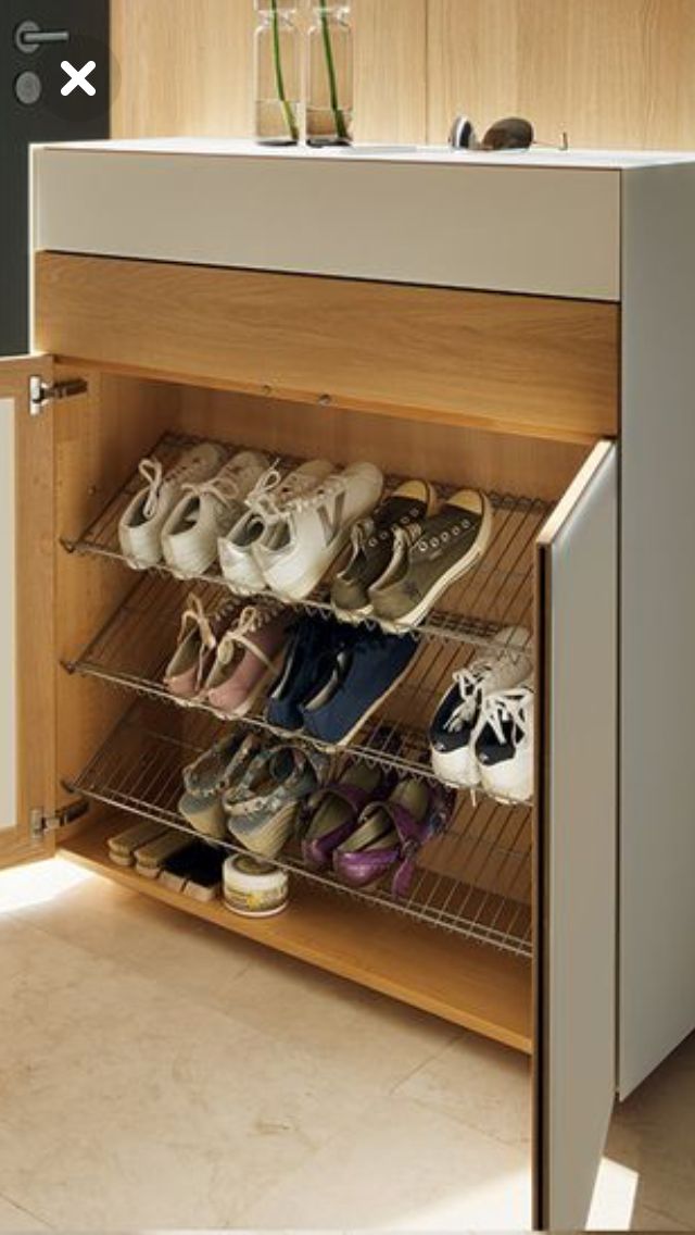 an open cabinet with several pairs of shoes on the bottom shelf in front of it