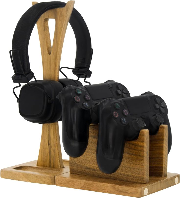 three video game controllers on wooden stand with headphones attached to the headset holder