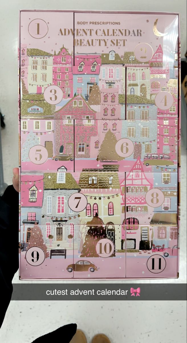 someone is holding up a pink and gold calendar with buildings in the middle on it