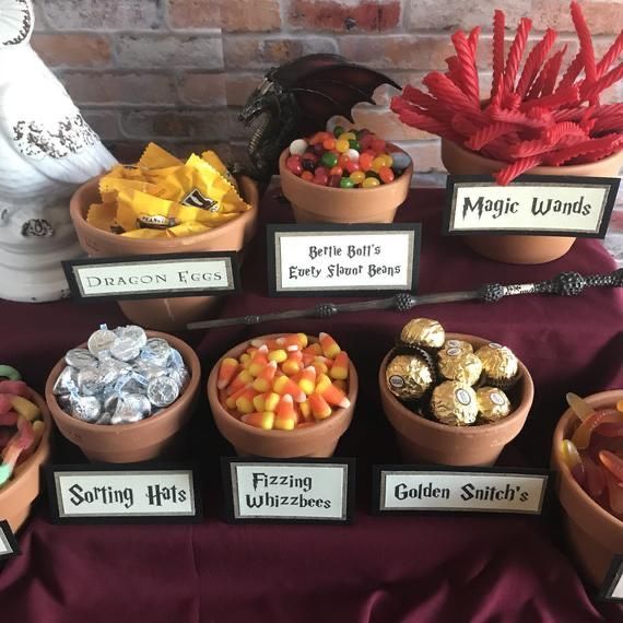 a table topped with lots of different types of candies and candy bar signs next to each other