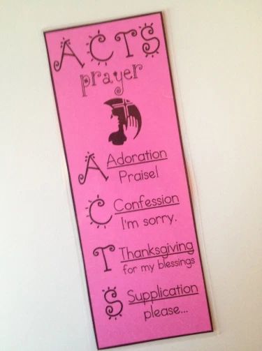 a pink bookmark hanging on the wall with words written in black and white ink