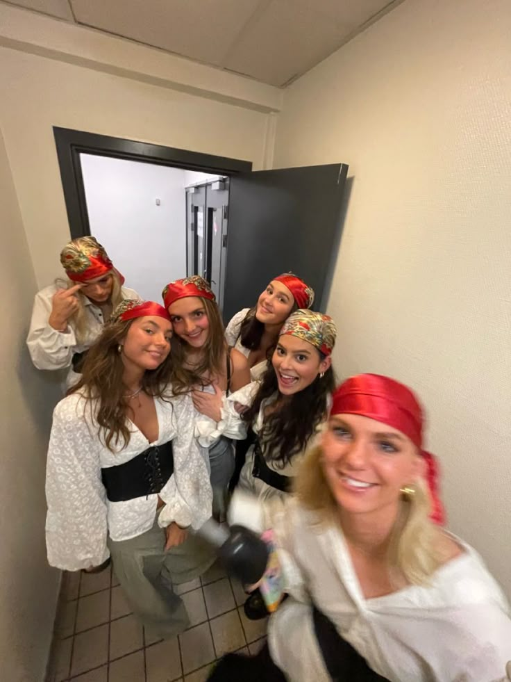 a group of women in pirate costumes taking a selfie