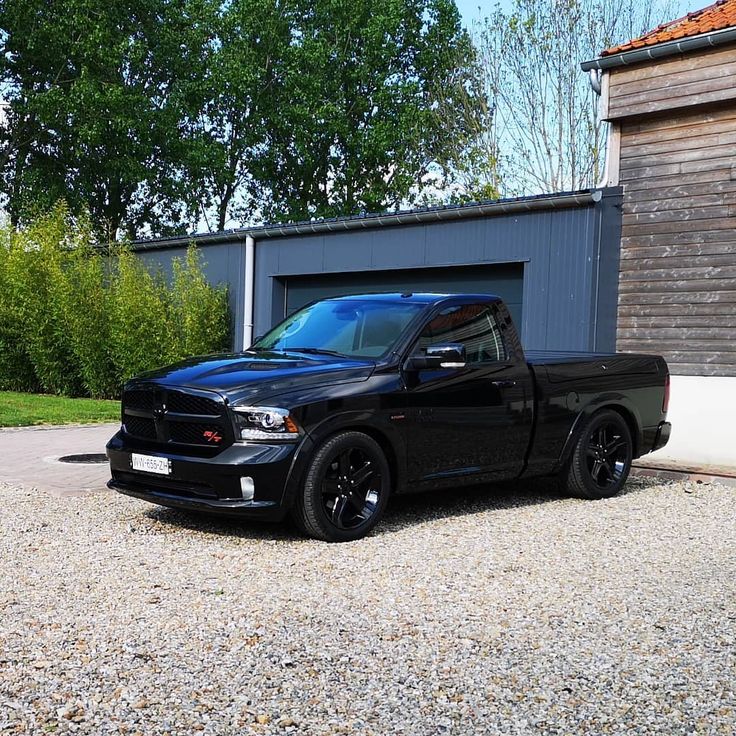 a black truck parked in front of a garage