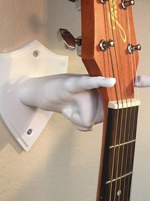 a person wearing white gloves is playing an acoustic guitar with their thumb on the strings