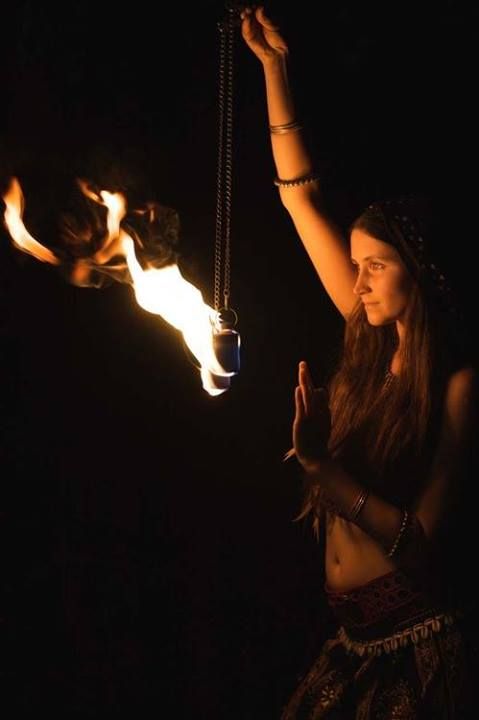 a woman holding a fire torch in the dark