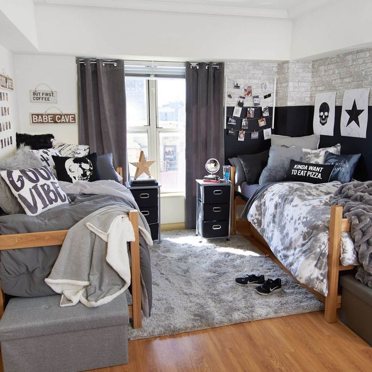 a bedroom decorated in black and white with grey bedding, gray rugs and wooden flooring