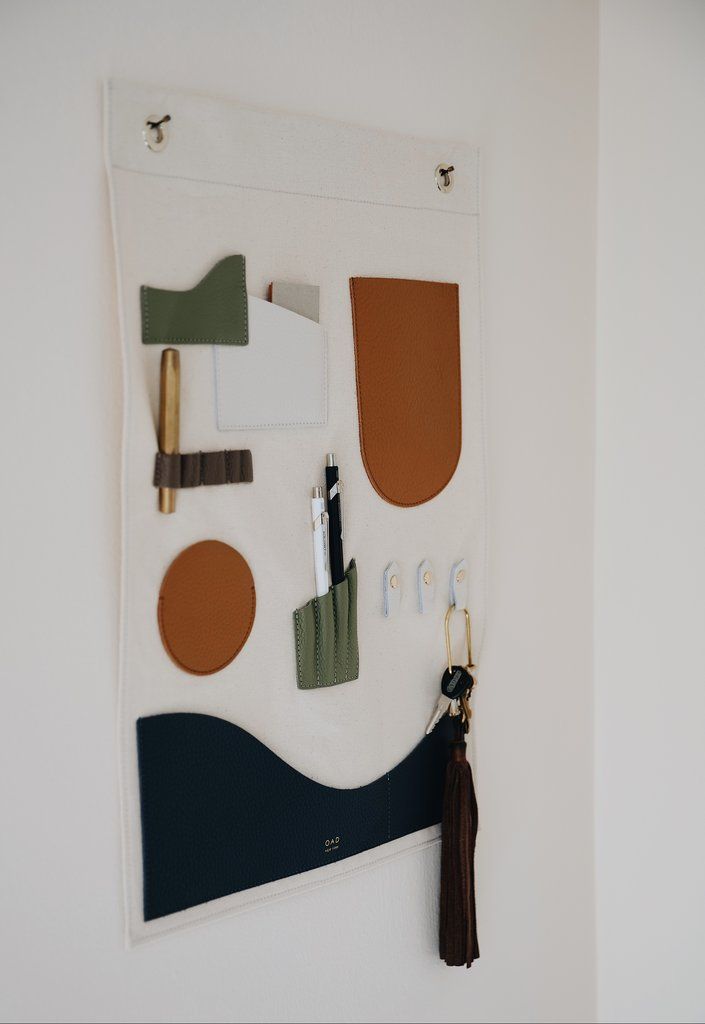 a white wall with various items hanging on it's side and a brown tassel