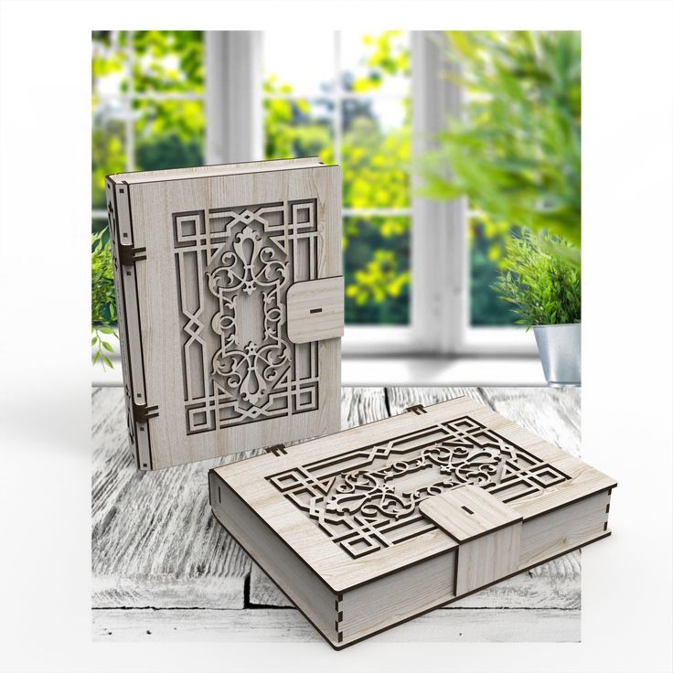 an open book sitting on top of a wooden table next to a potted plant