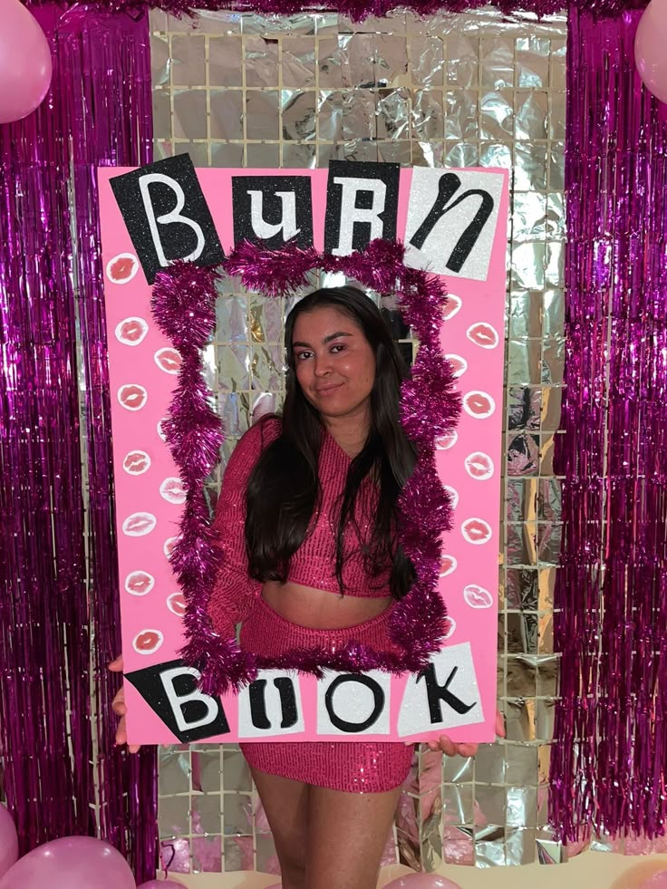 a woman in pink is posing for a photo with her name on the sign and balloons behind her