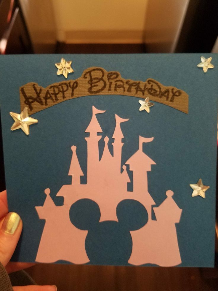 someone holding up a birthday card with a castle on it