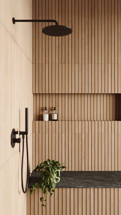 a bathroom with wood paneling and a plant in the corner on the wall next to the bathtub