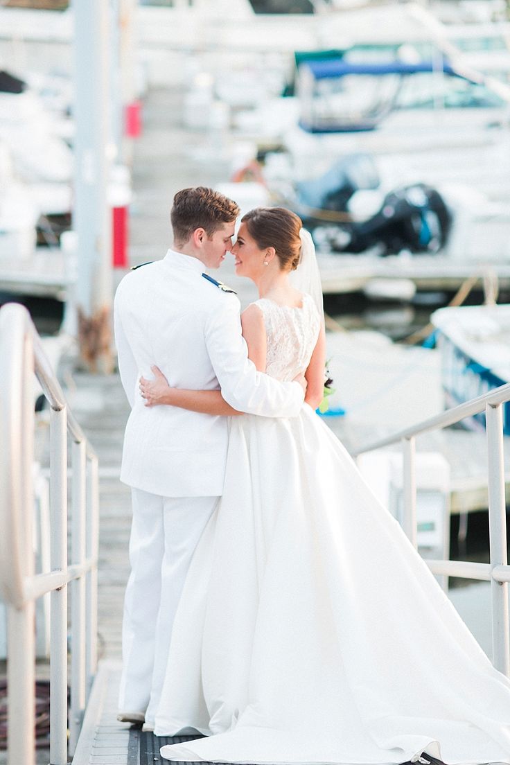 a bride and groom are standing on the dock