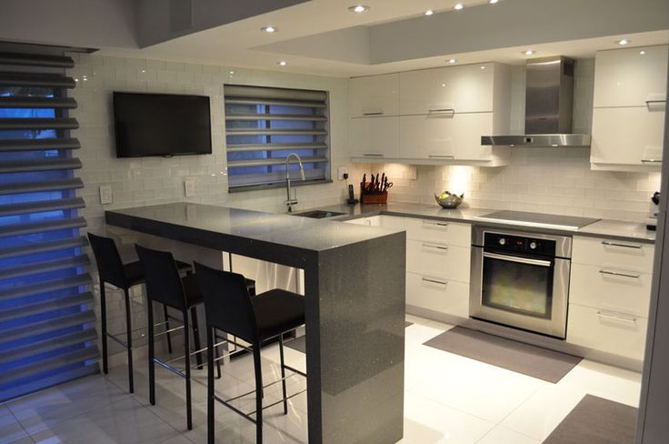 a kitchen with an island and bar stools in front of the stove top oven