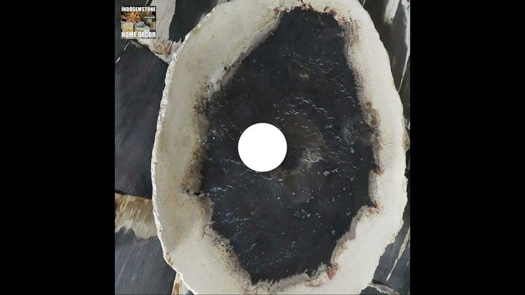 a black and white piece of wood with a hole in the center that looks like it has been burned