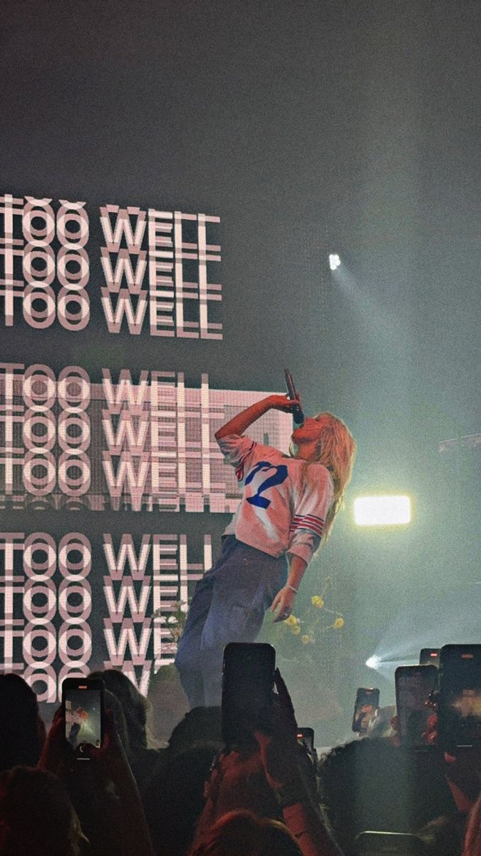 a man standing on top of a stage holding a microphone in front of a crowd