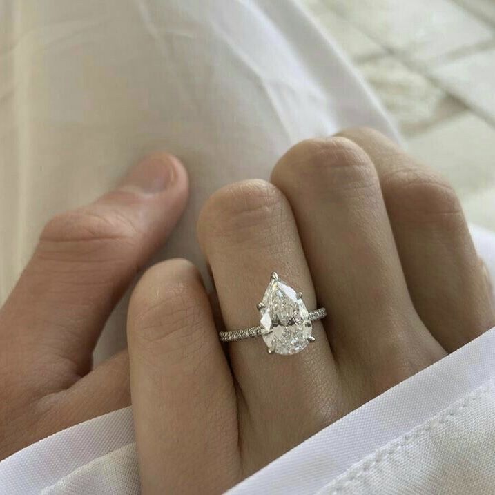 a woman's hand with a diamond ring on her finger and an engagement band