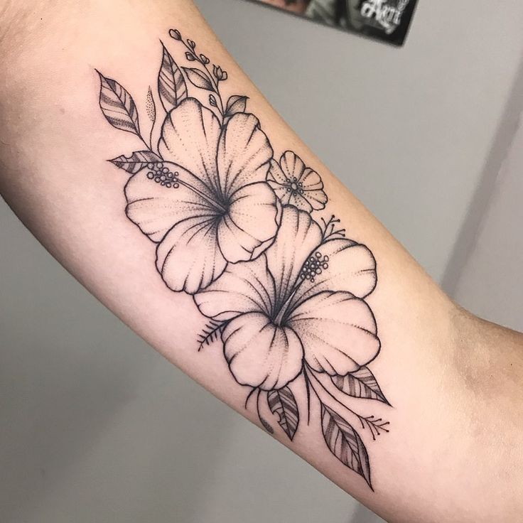 a black and white flower tattoo on the arm