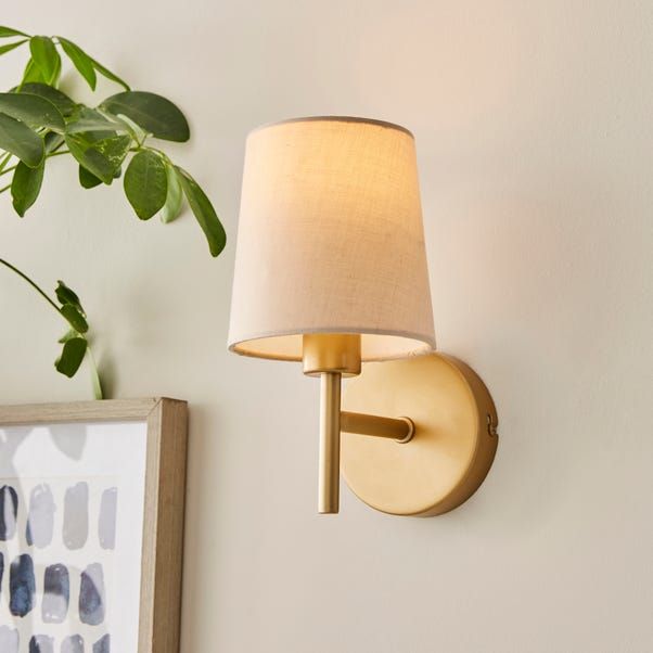 a lamp on the wall next to a potted plant